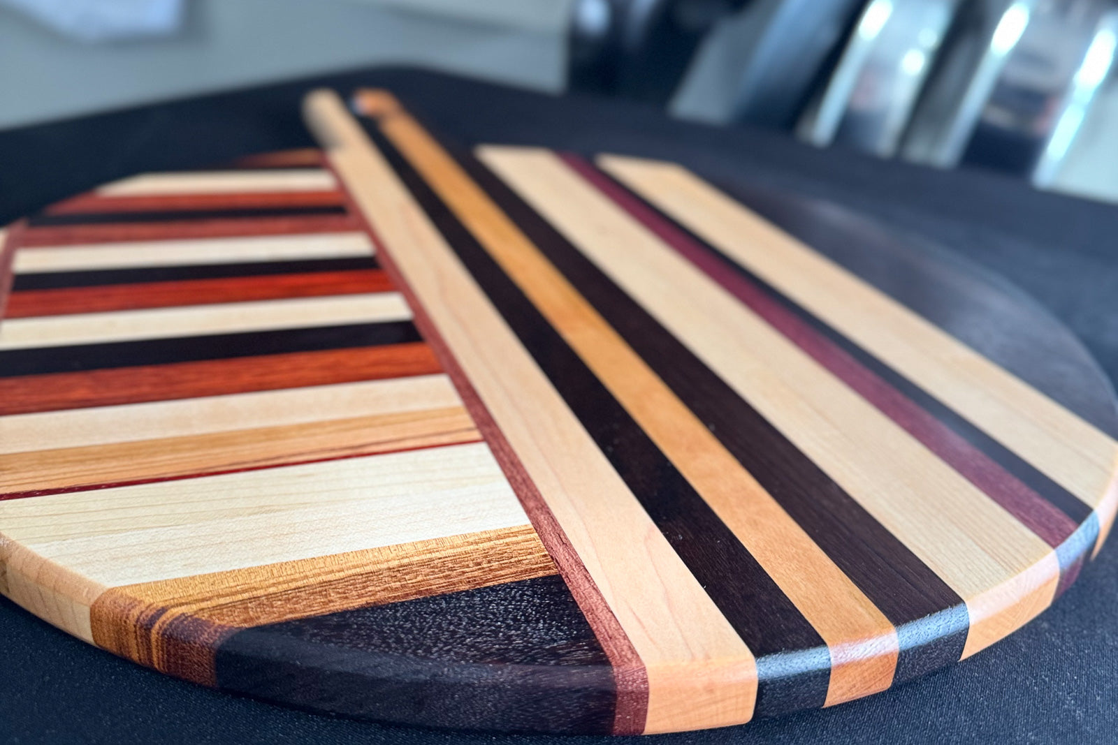 Close-up of Elora pizza board surface showing mixed hardwood grain pattern