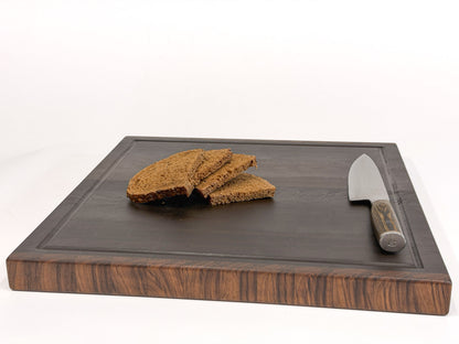 18 x 18 walnut end grain cutting board styled with sliced bread and a kitchen knife