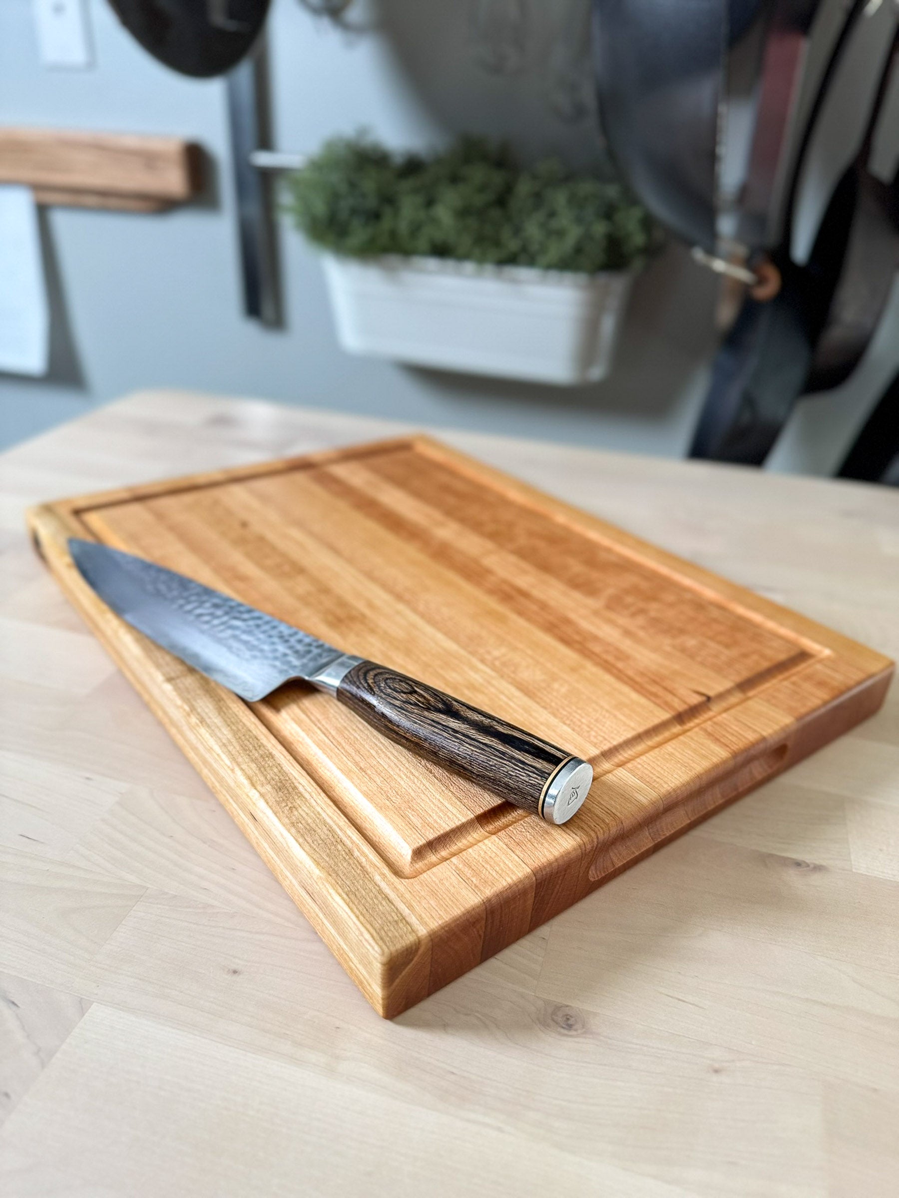 Corner detail of cherry edge grain cutting board showing grain pattern and juice groove