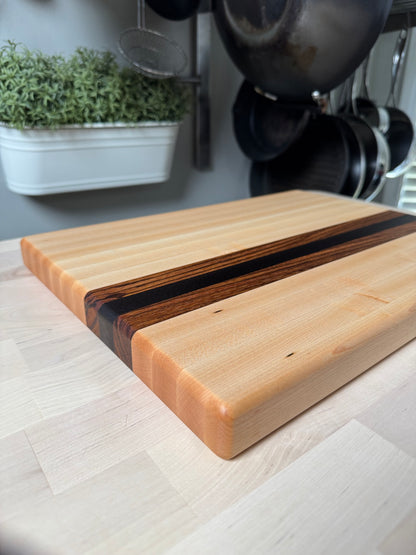 Angled view of the Cottingham edge grain cutting board in maple, walnut and zebrawood.