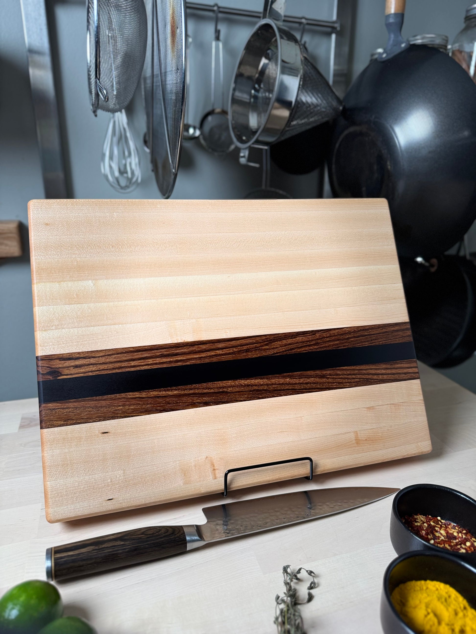Cottingham edge grain cutting board handcrafted from maple, walnut and zebrawood.