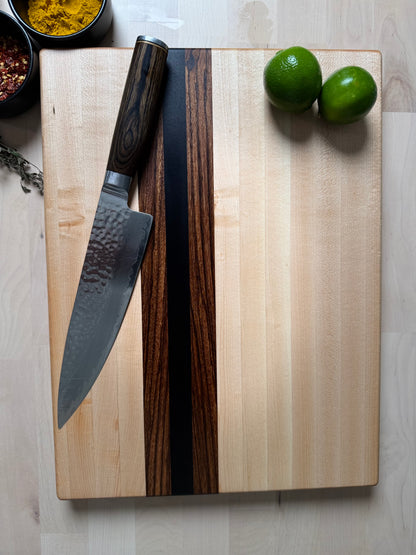 Top view of the Cottingham edge grain cutting board handcrafted from maple, walnut and zebrawood.