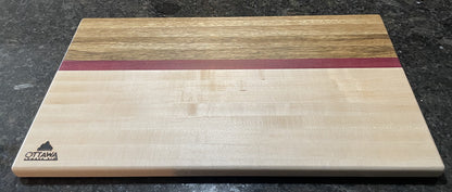 Landscape view of a handcrafted edge grain charcuterie board made from maple, black limba and Purpleheart.