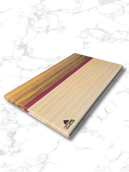 Edge grain charcuterie board made from maple, black limba and Purpleheart on a white background.