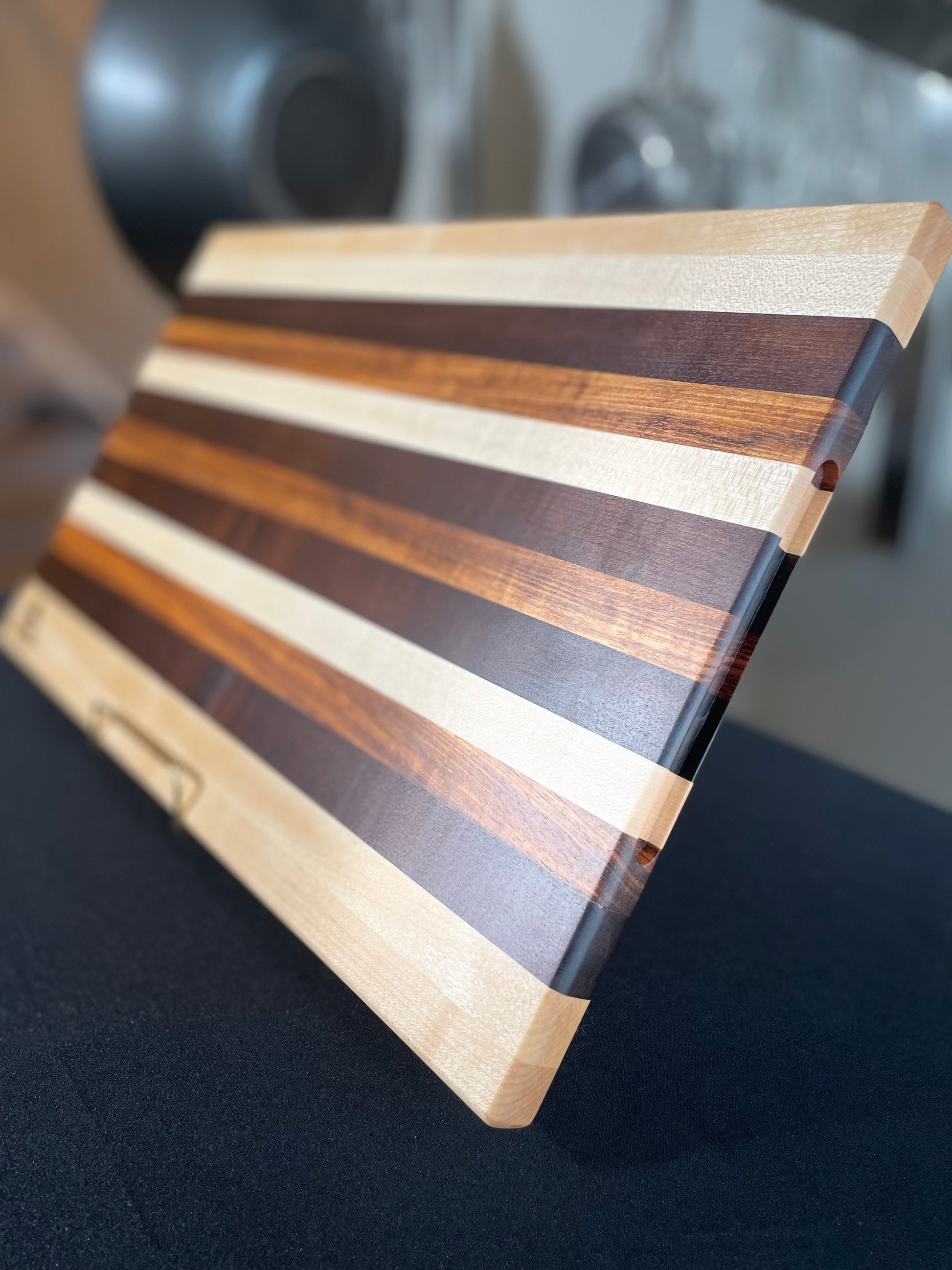 Handcrafted edge grain charcuterie board made from maple, walnut and tigerwood.