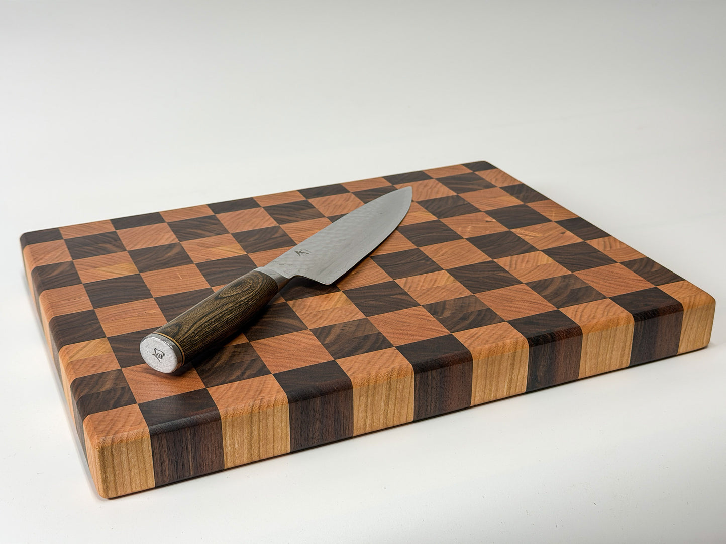 Angled view of end grain butcher block with chef knife, handmade mixed hardwood Ottawa