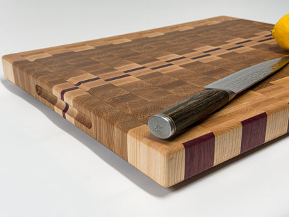 Low-angle close-up showing the end grain pattern and handcrafted hardwood construction of the cutting board.