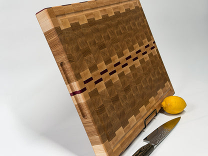 Angled view of a handcrafted end grain cutting board made from maple, white oak and Purpleheart hardwood.