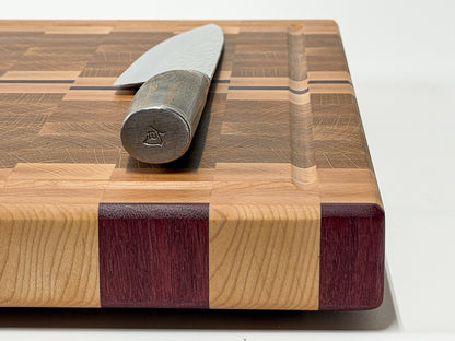 Side profile of a handcrafted end grain cutting board highlighting the maple, white oak and Purpleheart construction.