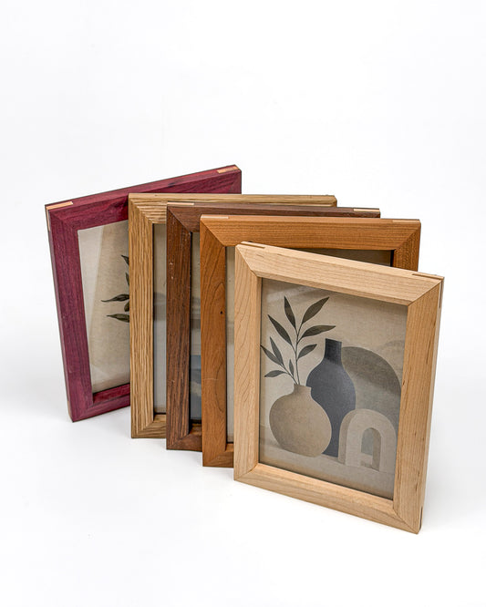 Five handmade picture frames in purpleheart, white oak, walnut, cherry and maple arranged on a white background.