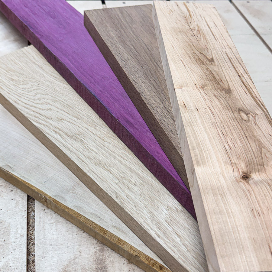 Premium hardwood lumber including walnut, white oak, purpleheart and other responsibly sourced wood species used in handcrafted woodworking projects.