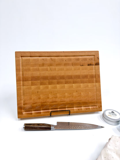 Langford maple end grain cutting board displayed upright with its juice groove and thick handcrafted construction