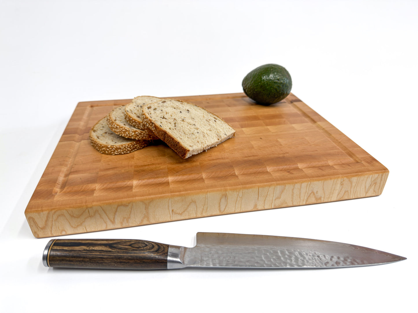 Langford maple end grain cutting board styled with sliced bread and a chef’s knife for kitchen serving