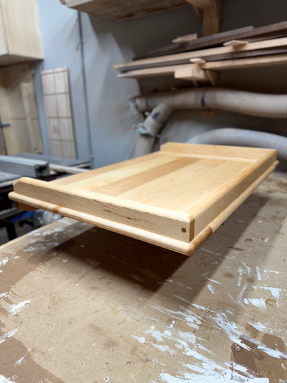Angled view of handcrafted maple pierogi board showing raised edges and smooth surface