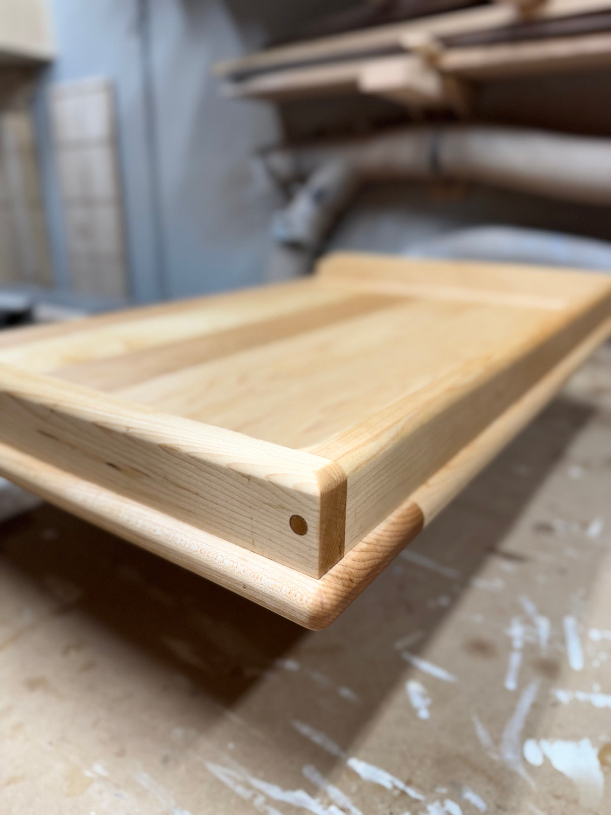 Side view close-up of maple pierogi board highlighting dowel joinery and lip depth