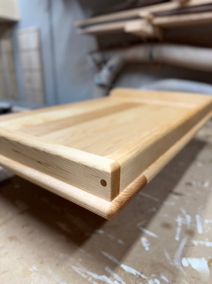 Side view close-up of maple pierogi board highlighting dowel joinery and lip depth