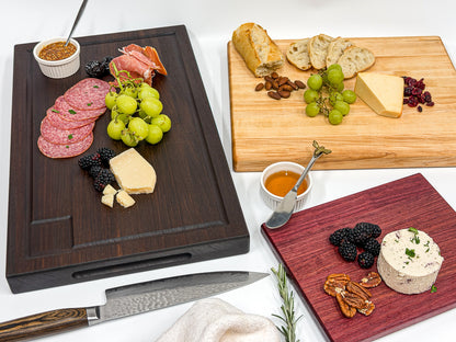 Three mix-and-match wood charcuterie boards arranged with meats, cheese, fruit and crackers.