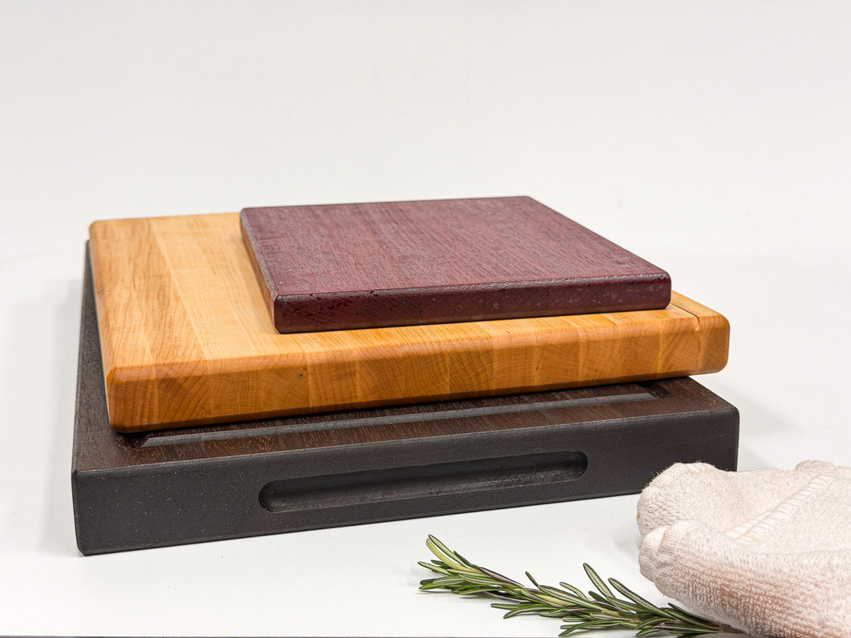 Walnut, maple and purpleheart cutting boards displayed upright in three sizes.