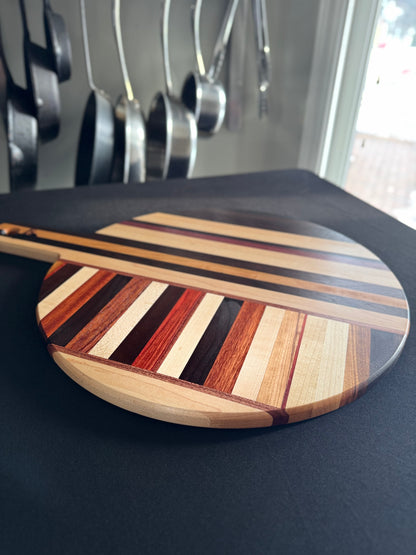 Side profile of handcrafted round pizza board showing thickness and wood grain