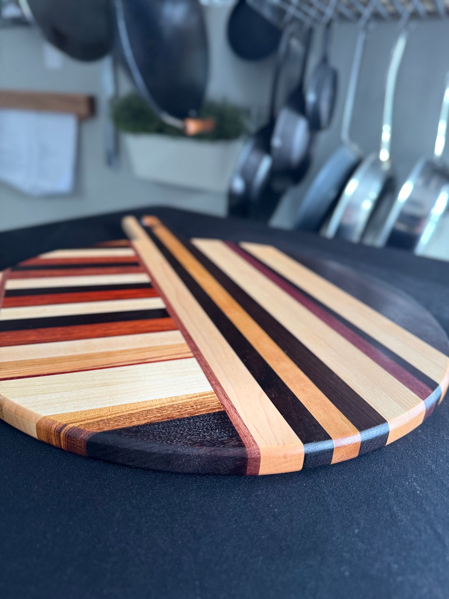 Close-up of Elora pizza board surface showing mixed hardwood grain pattern