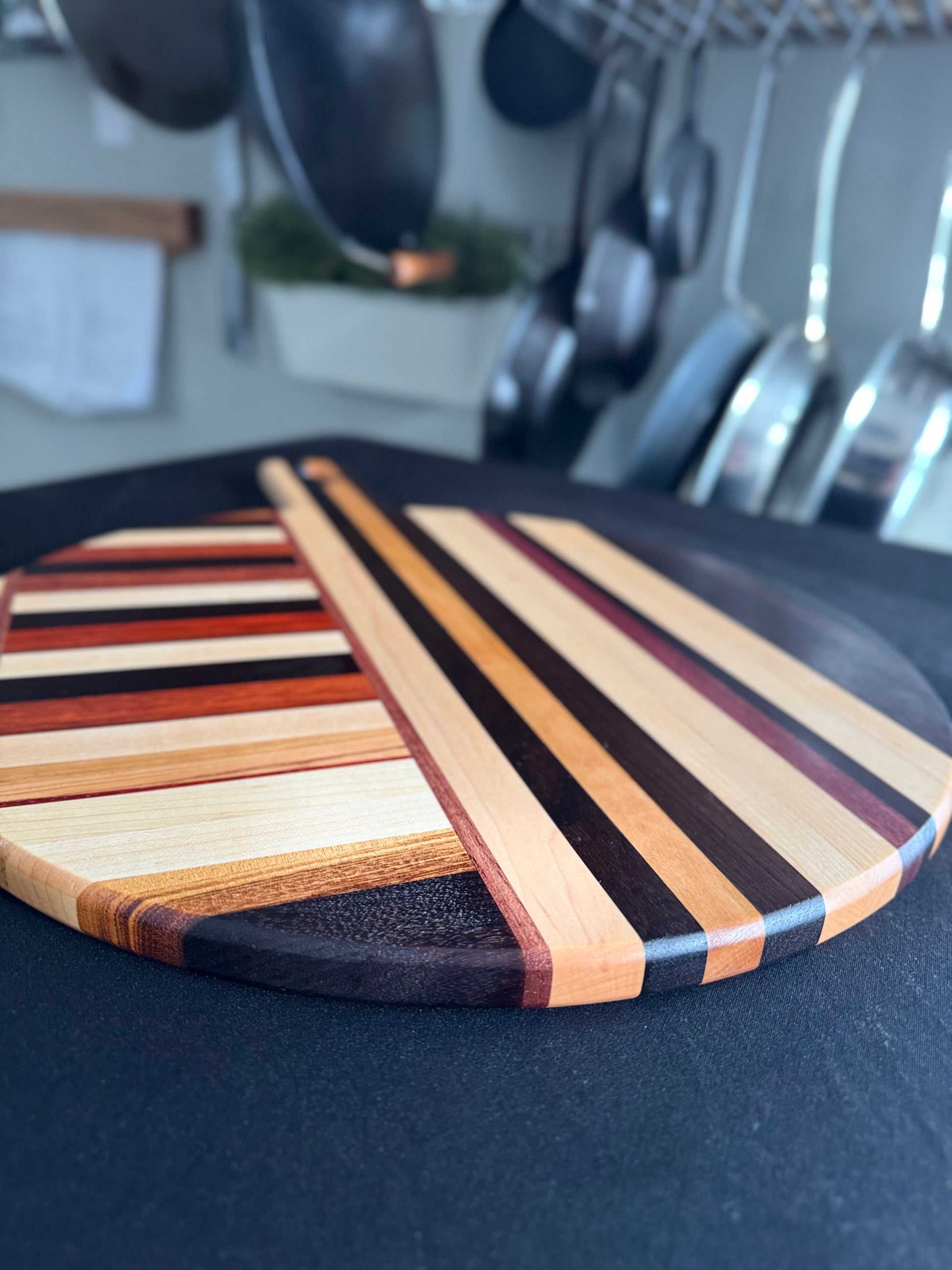 Close-up of Elora pizza board surface showing mixed hardwood grain pattern
