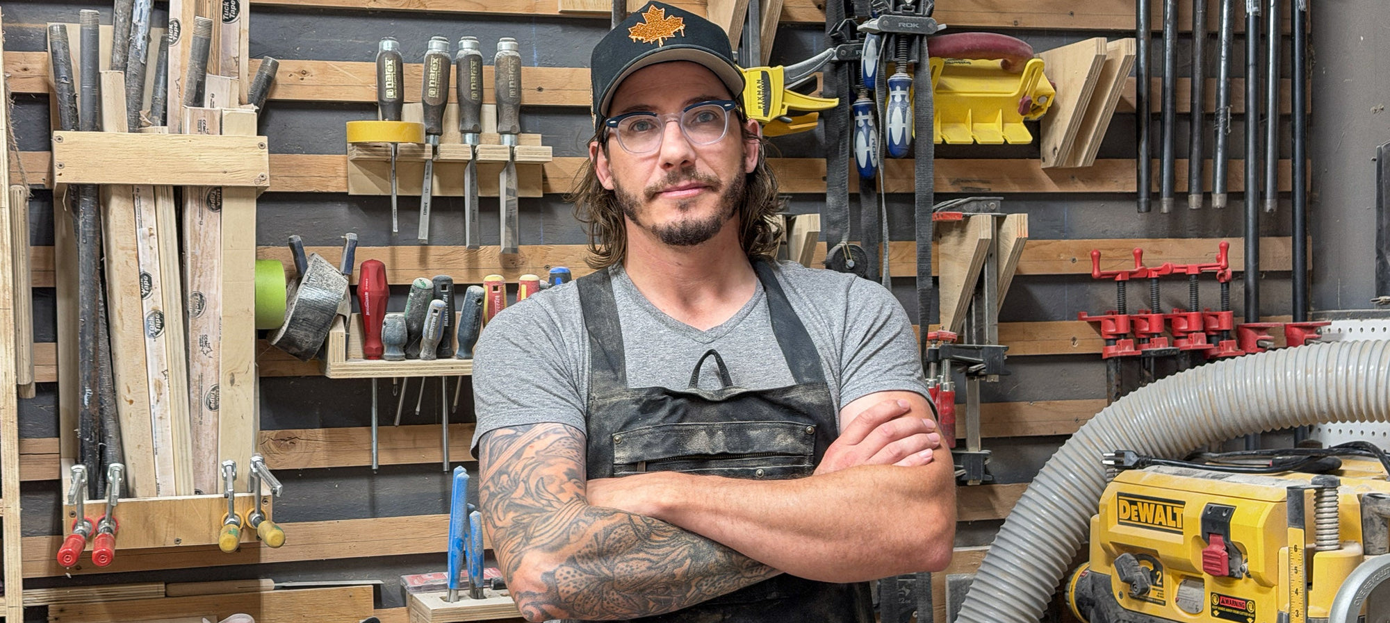 Ottawa Lumber Bin woodworker standing in his workshop surrounded by woodworking tools and equipment.