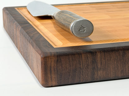 Corner detail of walnut edge grain cutting board with chef knife, handmade in Ottawa