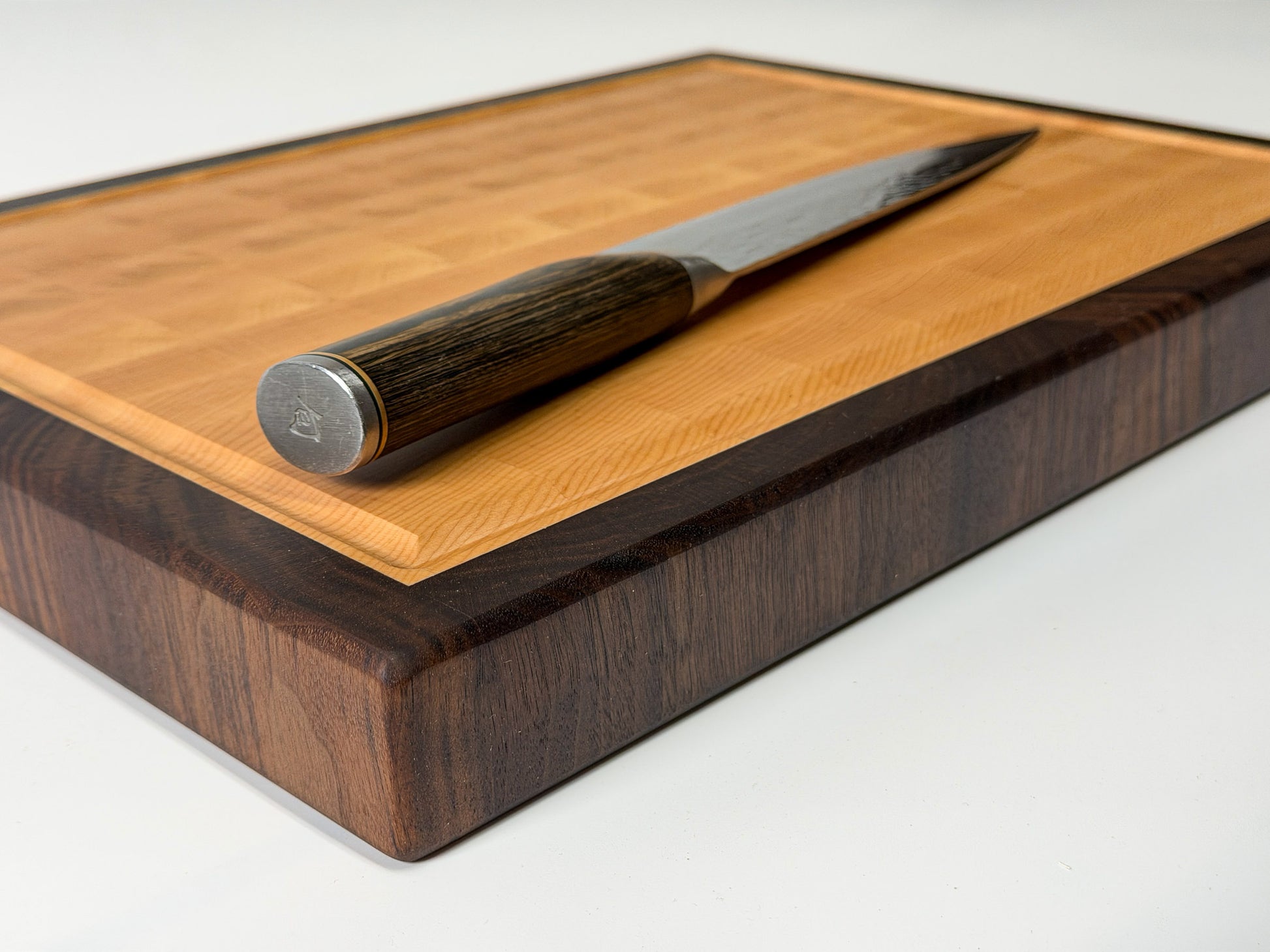 Angled corner shot of maple end grain cutting board with knife, handmade hardwood Ottawa