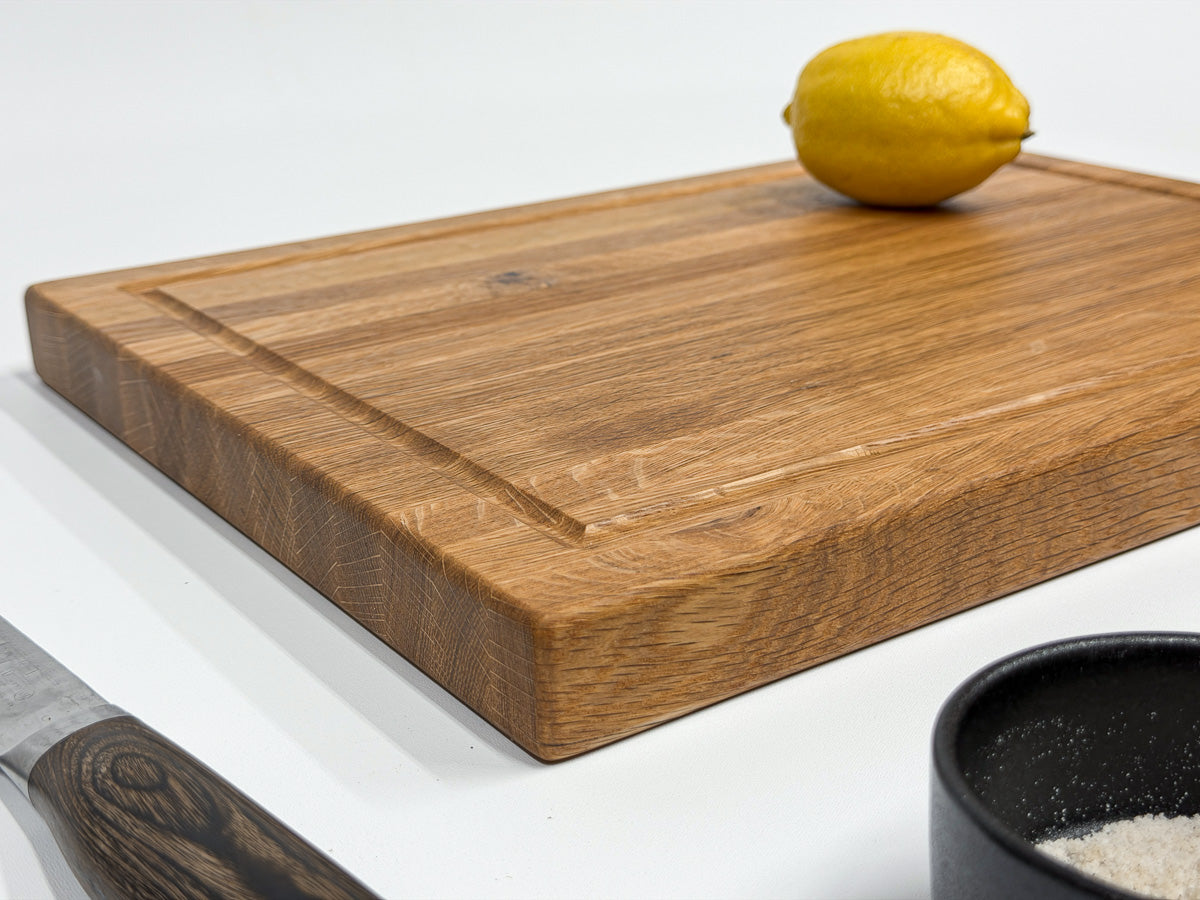 White oak cutting board styled with a lemon, chef's knife and salt cellar.