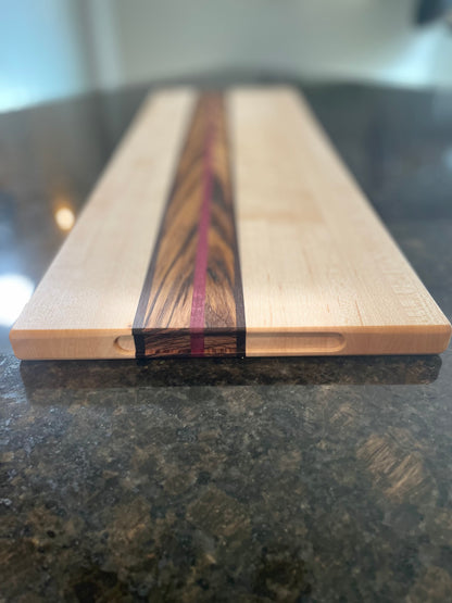 Close-up of the Zephyr charcuterie board showcasing its zebrawood, walnut and Purpleheart center accent.