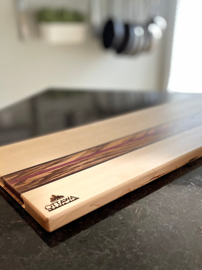 Side profile of the Zephyr charcuterie board highlighting the maple, zebrawood, walnut and Purpleheart construction.